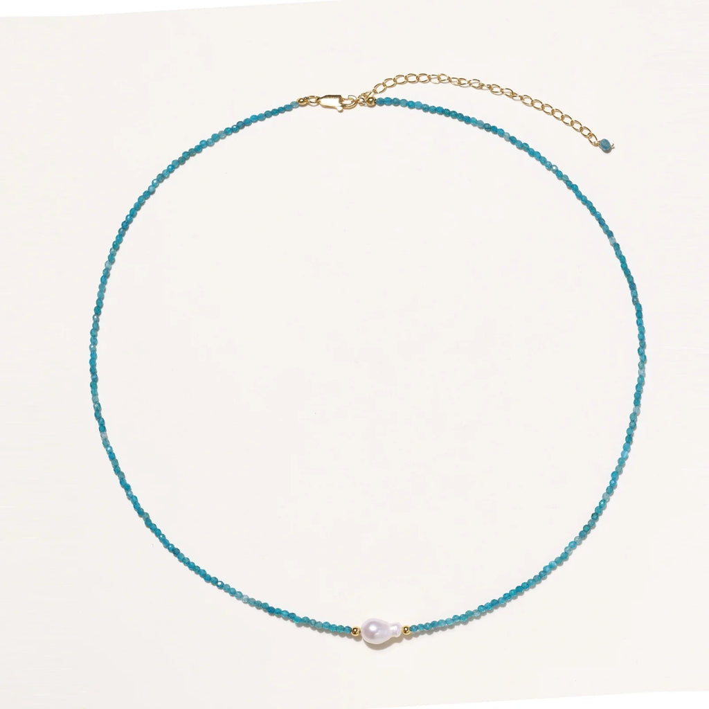 Delicate gold vermeil necklace with teal apatite beads and freshwater pearl on white background.