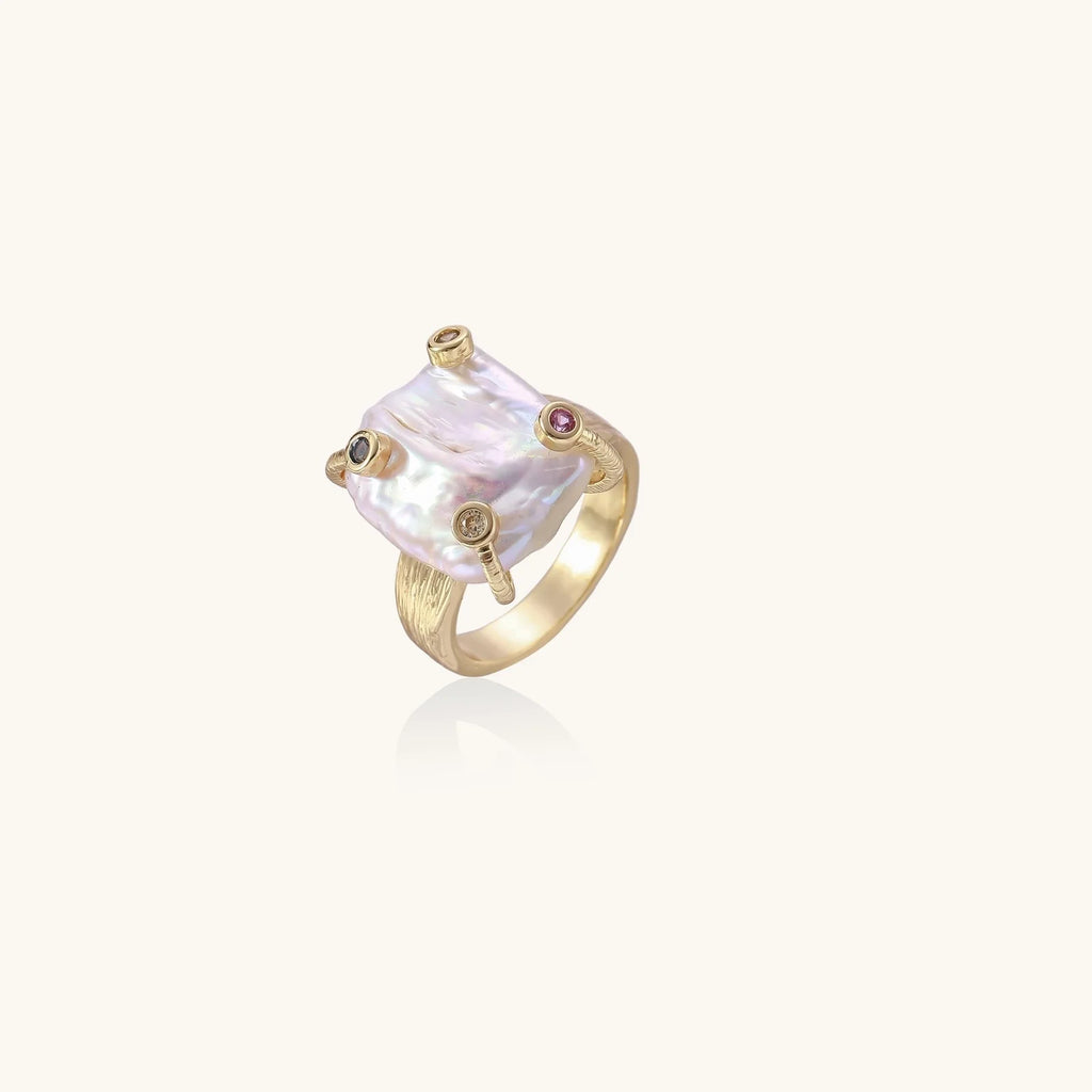 Gold ring with large iridescent baroque pearl and four colored gemstones on textured band