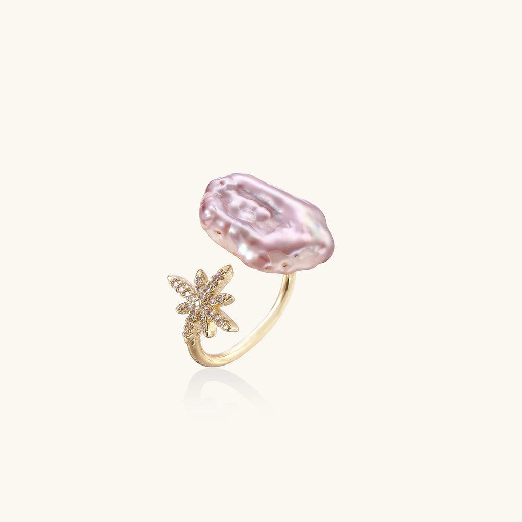 Adjustable gold ring with pink baroque freshwater pearl and crystal-studded star charm on white background