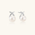 Rhodium-plated silver stud earrings with sparkling X design above lustrous round freshwater pearls on white background.