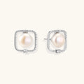 Rhodium-plated silver stud earrings with cushion frame, centered freshwater pearl, and tiny crystal accent