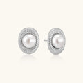 Oval rhodium-plated silver studs featuring freshwater pearls surrounded by pavé crystal halo on white background
