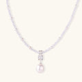 Dainty necklace with lavender crystal beads, freshwater pearls, geometric pendant, and large pearl drop on white background.