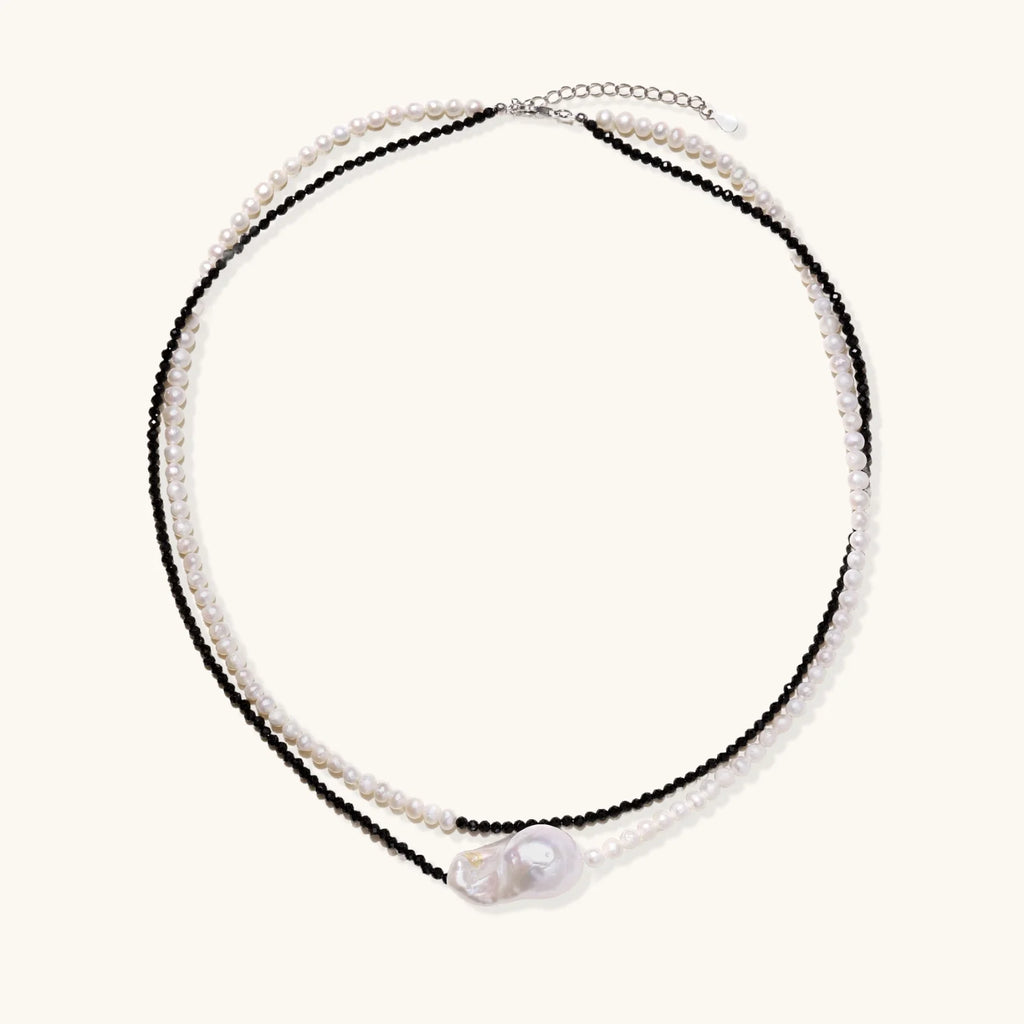 Double-strand necklace with black faceted quartz and white pearls featuring an oversized baroque pearl centerpiece