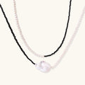 Double-strand necklace with black faceted quartz and white pearls featuring an oversized baroque pearl centerpiece