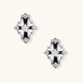 Pair of Art Deco-style stud earrings with star crystals, black enamel accents, and white gold plating on ivory background.