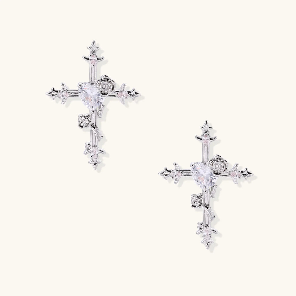 Two-tone cross earrings with gold roses and crystal stars on silver hoops, dangle drop style on white background.