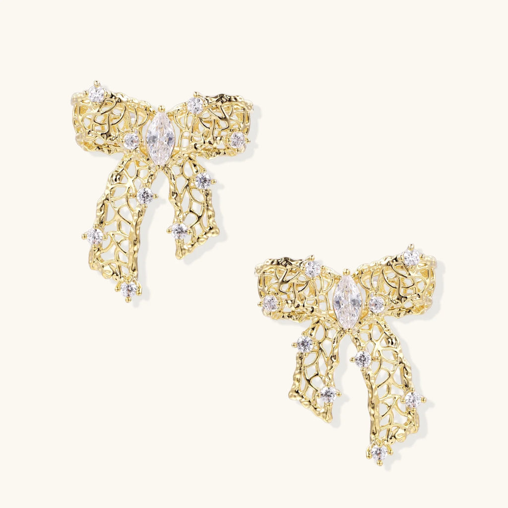 Filigree bow-shaped earrings with marquise center stone and lattice ribbon tails in gold and silver finishes