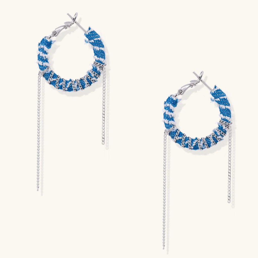 Medium hoop earrings wrapped in blue striped denim fabric with dangling silver chains on white background.