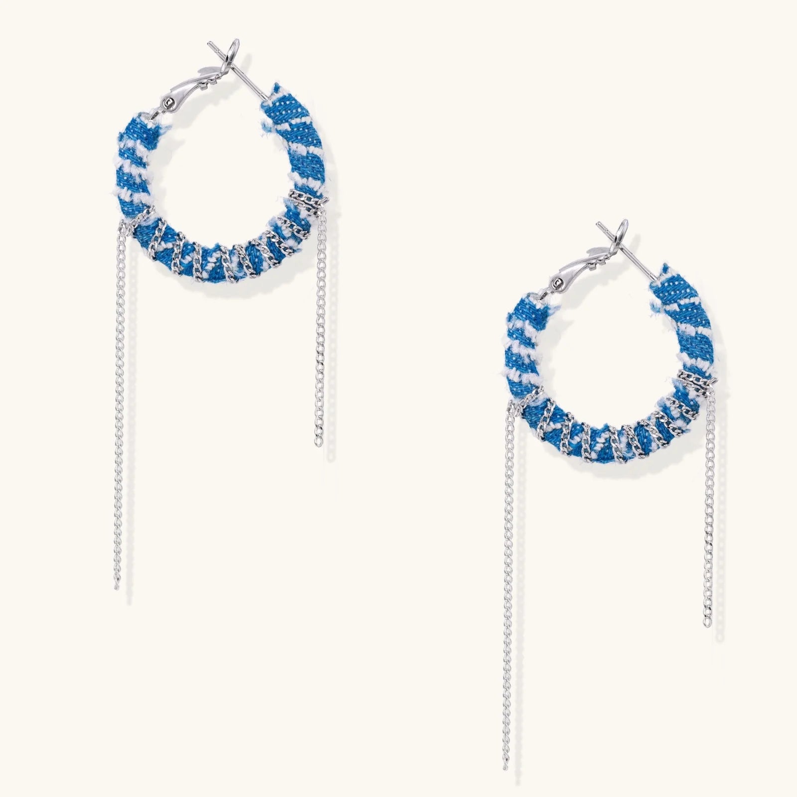 Medium hoop earrings wrapped in blue striped denim fabric with dangling silver chains on white background.