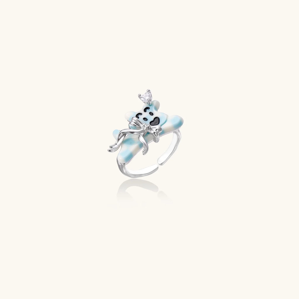 Adjustable white gold-plated ring with 3D blue enamel puppy wearing crystal crown on beige background