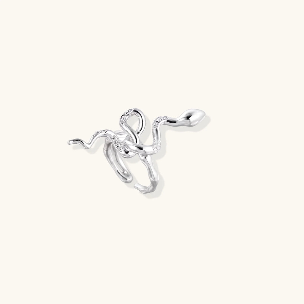 Sculptural white gold-plated snake ring with crystal accents coiling around finger in bold open design