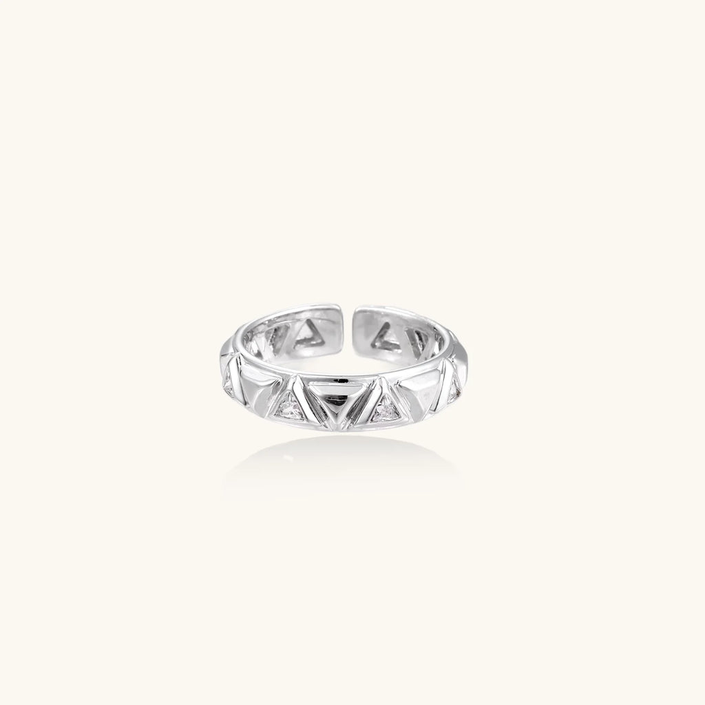White gold adjustable ring with geometric triangle cutouts and zirconia stones on cream background