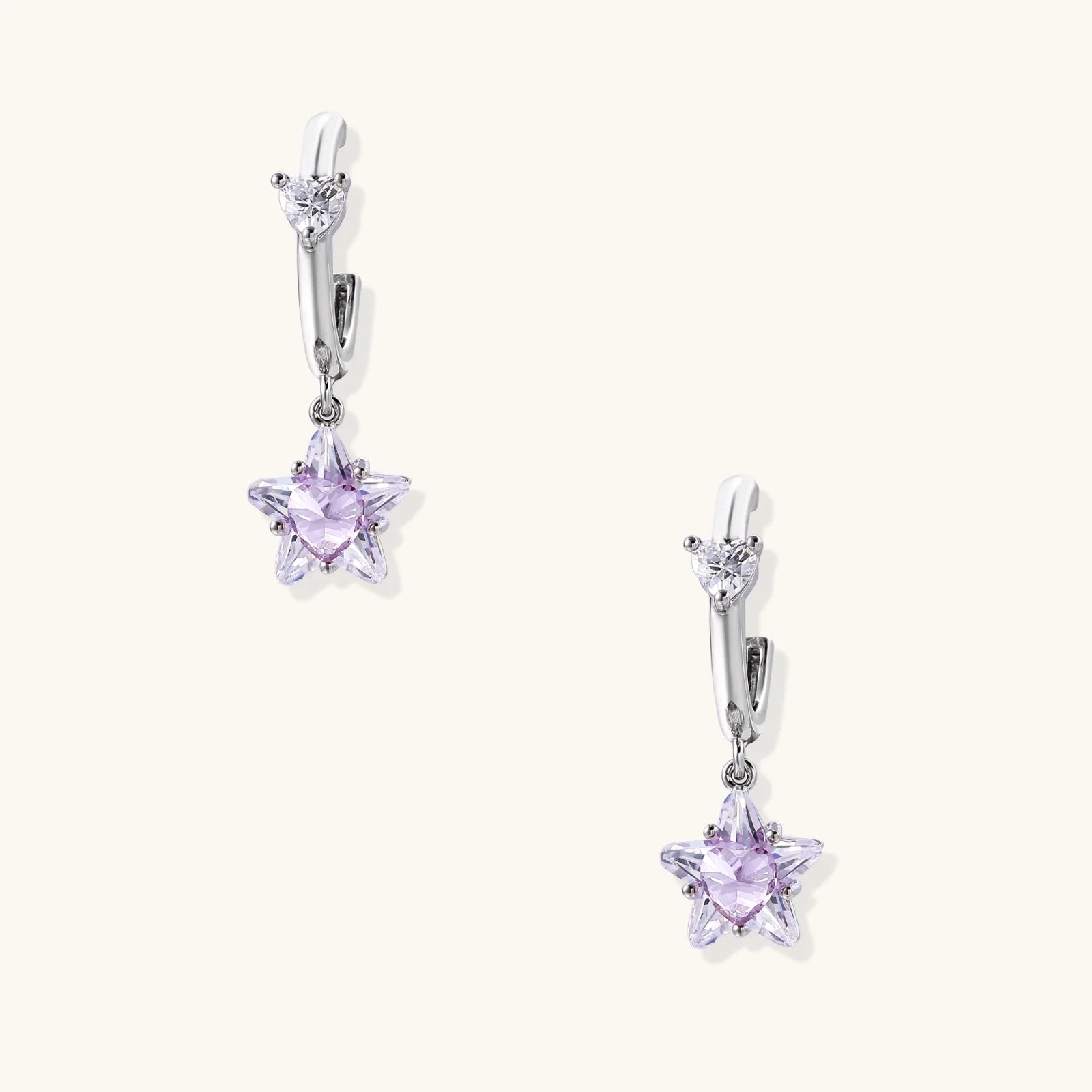 White gold plated huggie earrings with clear CZ accents and dangling lavender star-shaped crystals on cream background