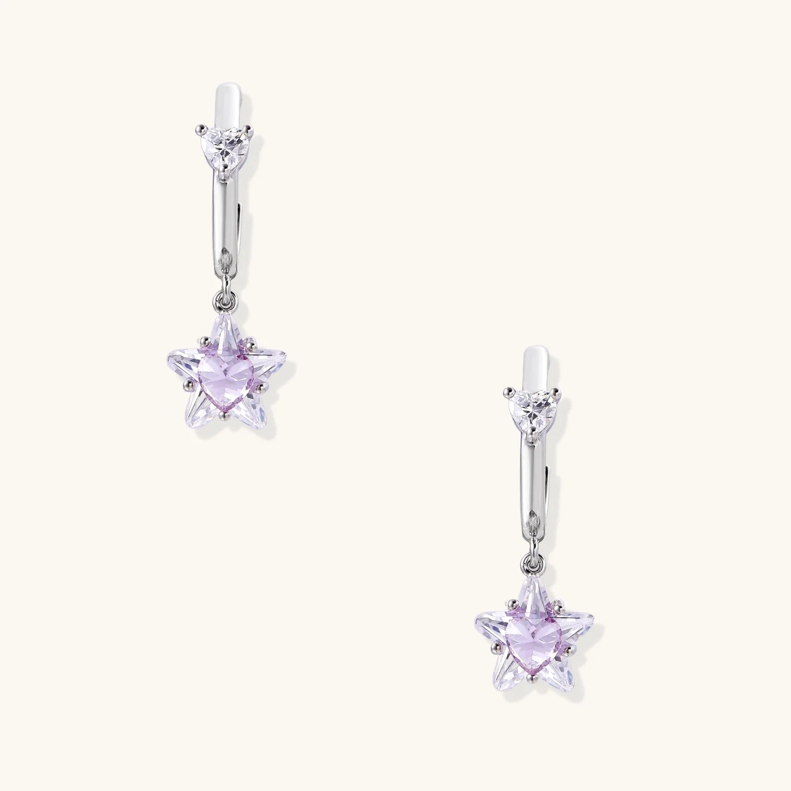 White gold plated huggie earrings with clear CZ accents and dangling lavender star-shaped crystals on cream background