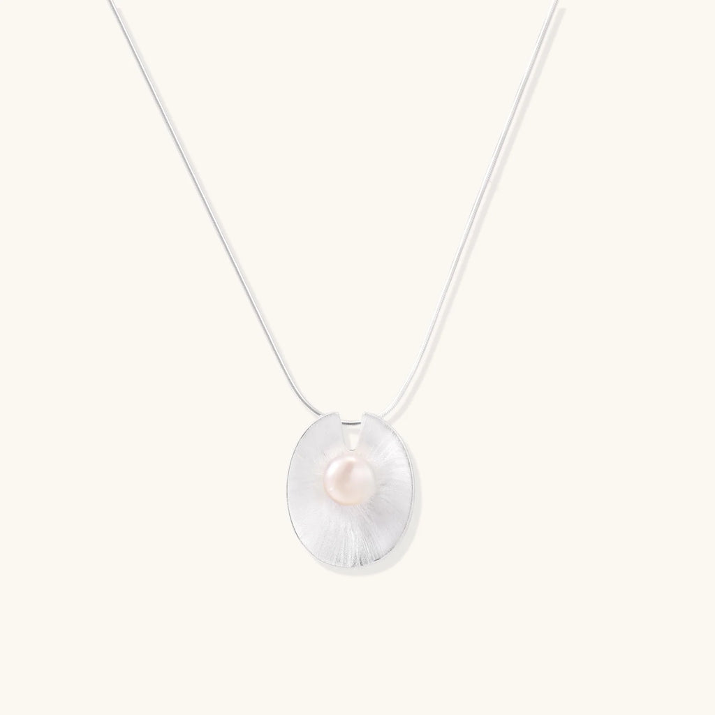 Sterling silver disc necklace with textured finish and centered freshwater pearl on delicate chain