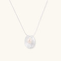 Sterling silver disc necklace with textured finish and centered freshwater pearl on delicate chain