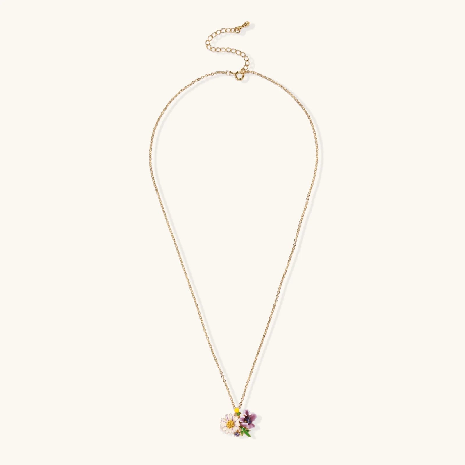 Gold-plated necklace with pink and purple enamel flower pendant featuring crystal accents on cream background