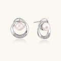 White gold-plated brass earrings with circular design, freshwater pearl center, and diamond accents