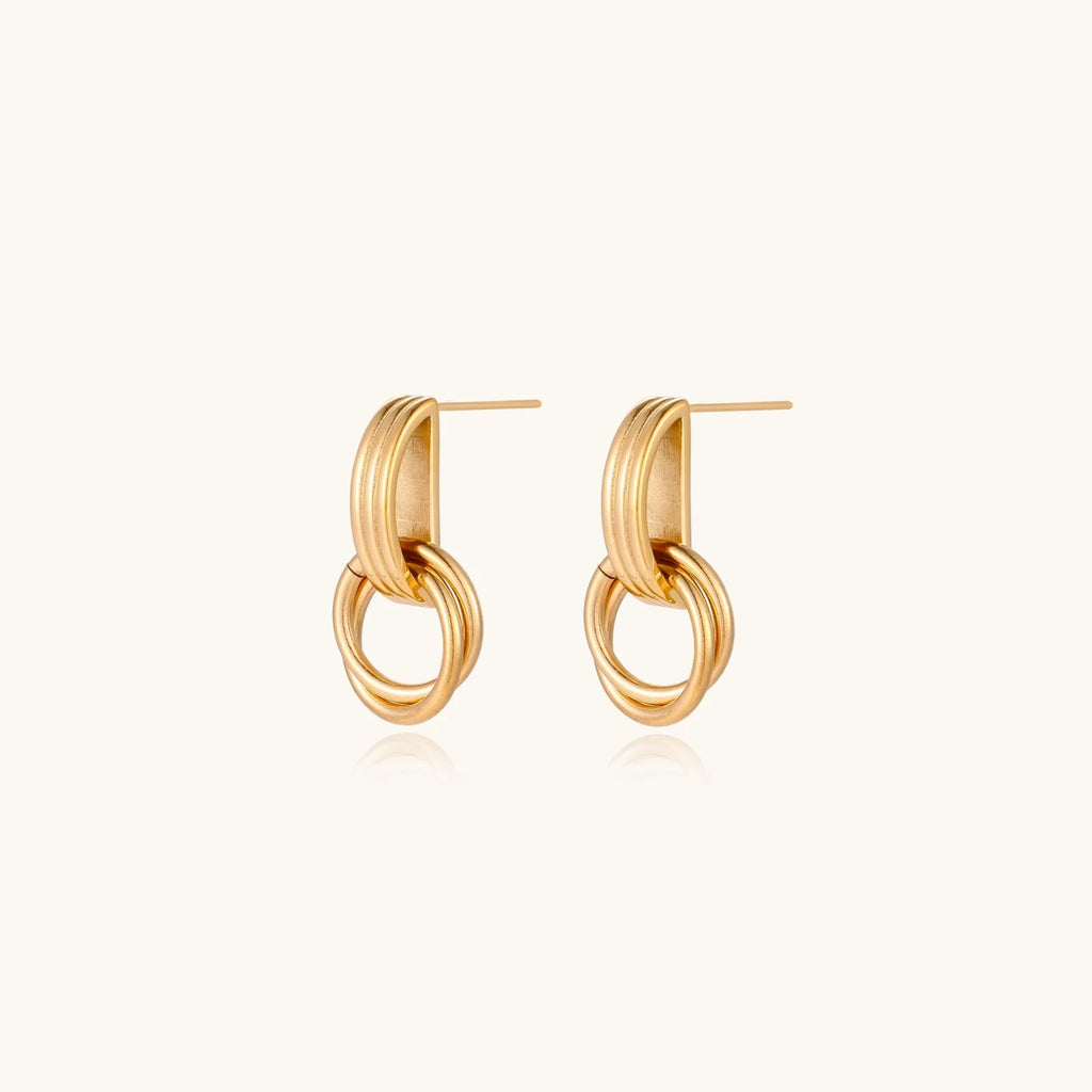 Gold stud earrings with vertical ridged bar connecting to triple interlocking circular rings on white background