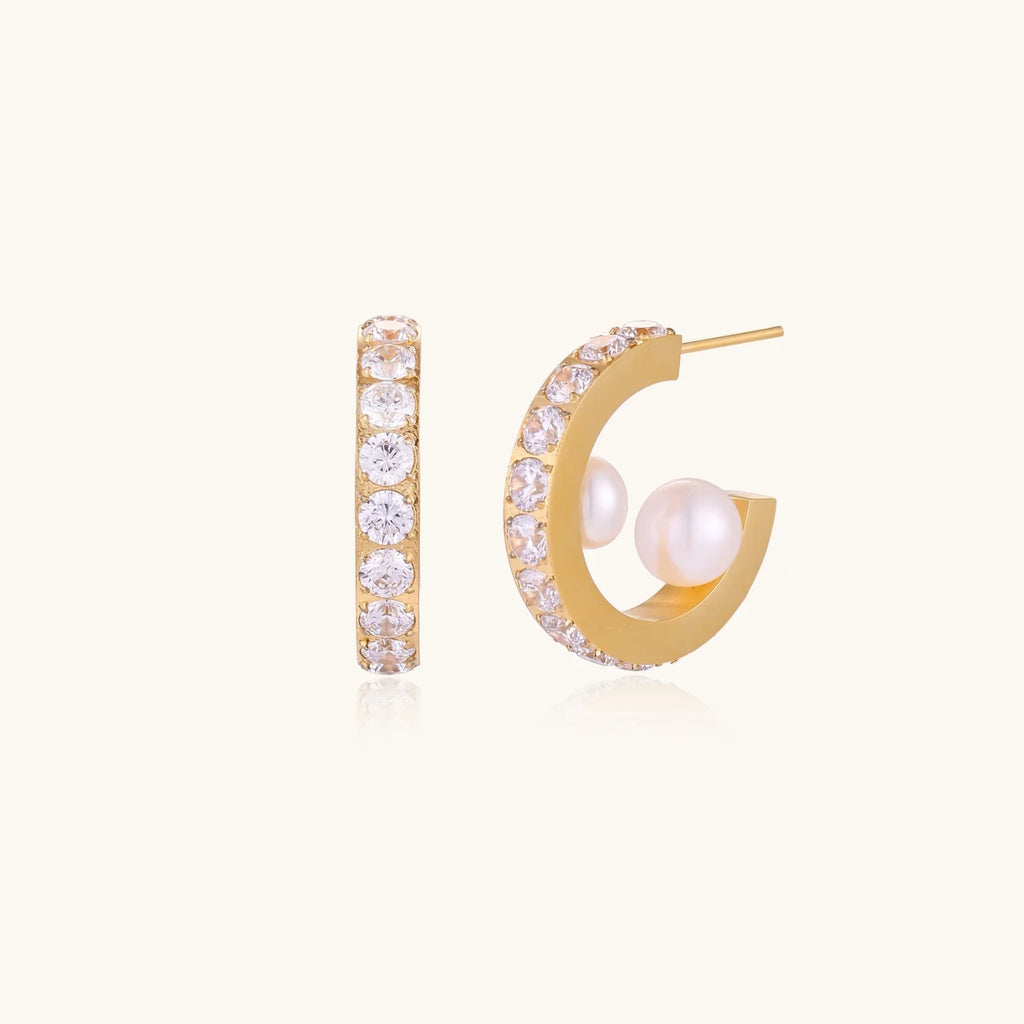 Gold pavé hoop earrings with two freshwater pearls nestled inside the curved design, featuring crystal-studded outer edge.