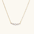 Delicate 14K gold-plated necklace with five graduated zirconia stones arranged in a curved arc on fine chain