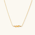 Dainty 18K gold plated necklace with infinity knot pendant on delicate chain against white background