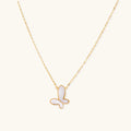 Gold-plated butterfly pendant with iridescent mother of pearl inlay on delicate chain against cream background.