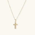 Delicate 14K gold-plated cross pendant with crystal accents on fine chain against cream background