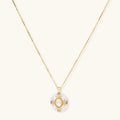 Gold-plated necklace with circular white enamel pendant featuring central zirconia stone and ornate decorative details